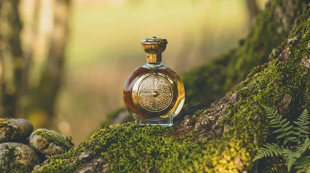 Парфуми Boadicea The Victorious Defender у флаконі із золотим кельтським щитом серед лісового моху.